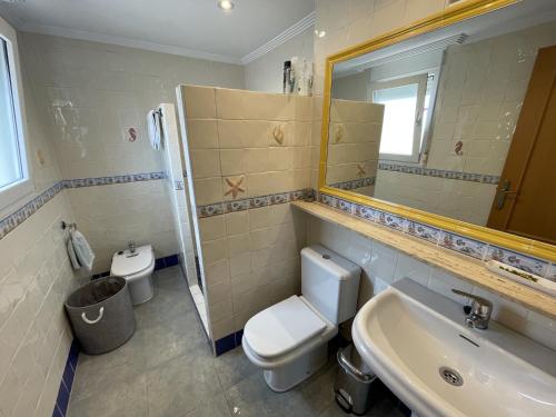 Un baño con inodoro, lavabo y espejo. en Ático con vista al Mar Menor, en Santiago de la Ribera