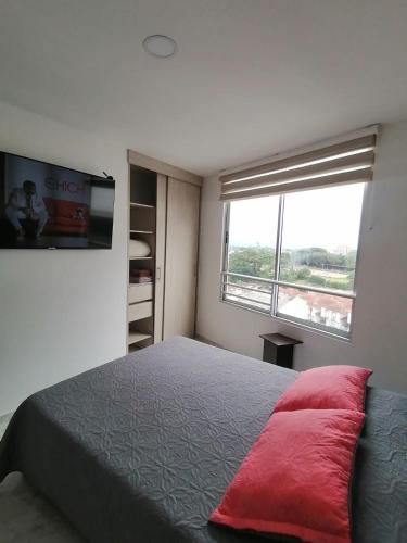 Un dormitorio con una cama grande y una ventana en Apartamento con la mejor ubicación y descanso en Armenia