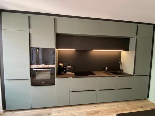 a kitchen with white cabinets and a black appliance at New 5min to Little Venice - Close to Xmas Fair in Colmar