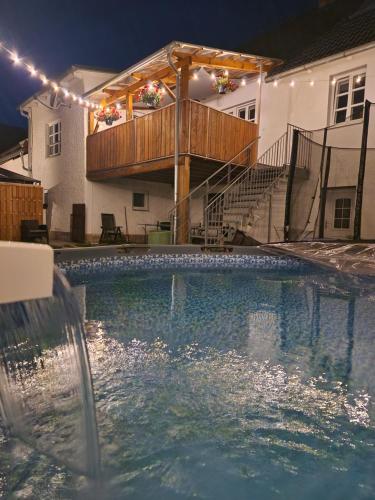 a swimming pool in front of a house with lights at Ferienhaus del Pueblo 