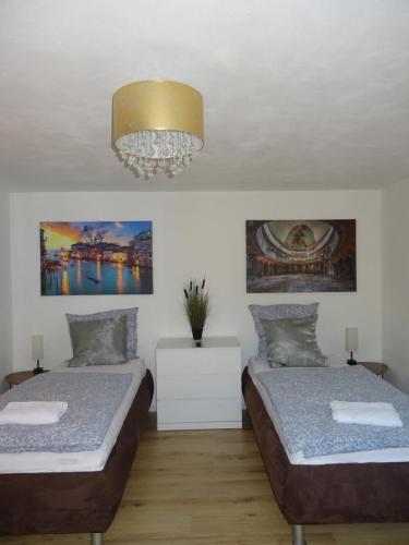 a bedroom with two beds and a chandelier at Ferienhaus del Pueblo in Bechtsrieth