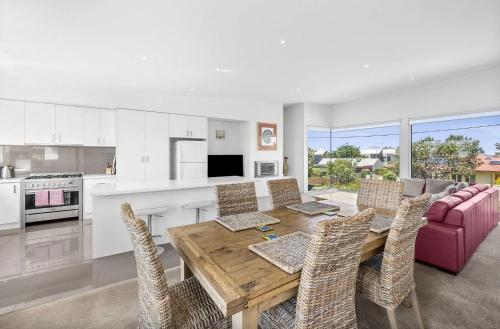 a kitchen and dining room with a wooden table and chairs at Saltwater Serenity - Townhouse with a View in Torquay