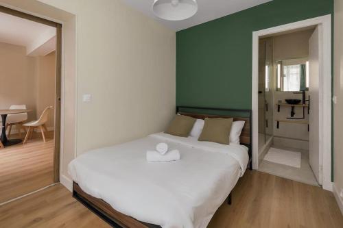 een slaapkamer met een wit bed en een groene muur bij Appartement 2P Confort Hyper Centre & 100m de la plage in Dieppe