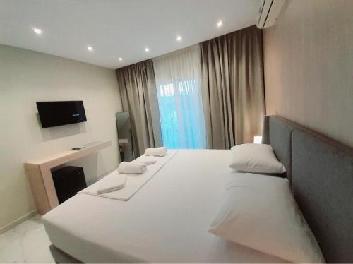 una camera d'albergo con un grande letto con cuscini bianchi di GB Rooms a Ksamil