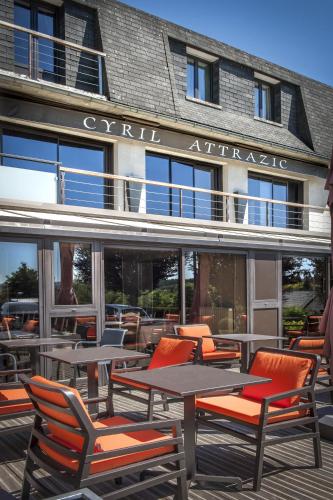 a group of tables and chairs in front of a building at Logis Hôtel et Spa Chez Camillou in Aumont-Aubrac