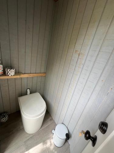 a small bathroom with a toilet in the corner at Little Birds Treehouse in Sparrow Bush
