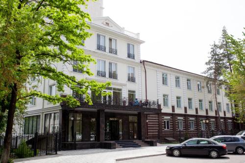 a black car parked in front of a white building at Park Hotel Bishkek in Bishkek