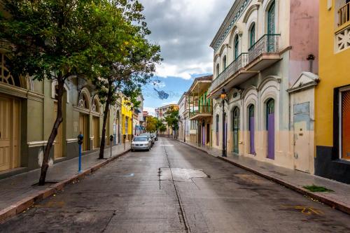 an empty city street with a car parked on the road at Expansive Paradise with Private Jacuzzi and Tropical Patio in Ponce
