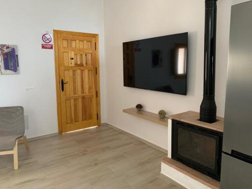 sala de estar con TV y chimenea en Casa del Portillete, en Montejaque