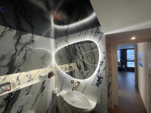 ein Bad mit einem Waschbecken und einem Spiegel in der Unterkunft Mazot Agora Suite - Pop-Up Gallery Experience Suite in Salvan