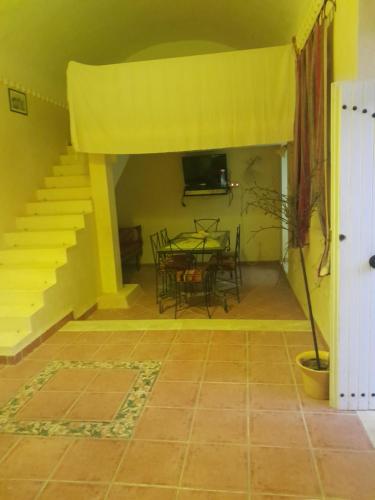 una sala da pranzo con tavolo e soffitto giallo di Dar Rita a Houmt Souk
