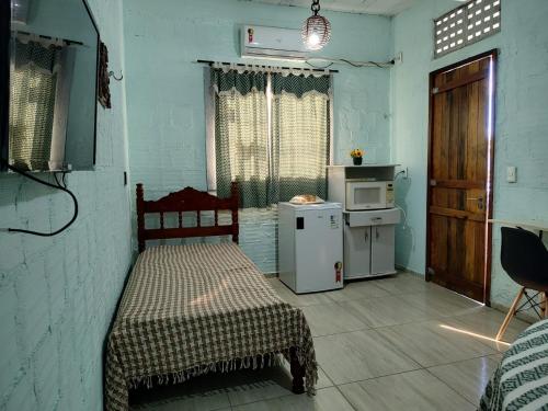 een kamer met een bed en een kleine keuken bij Casa Rustica in Baía da Traição