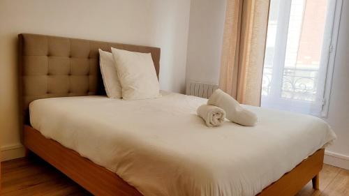 un lit avec un animal rembourré assis au-dessus dans l'établissement Clichy Luxe Living, à Clichy