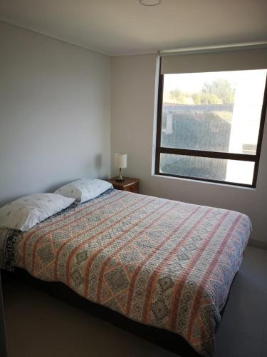 a bedroom with a bed with a large window at Departamento de Lujo Pingueral in Concepción