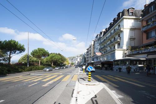 an empty city street with cars driving down the road at Hotel Parc & Lac in Montreux