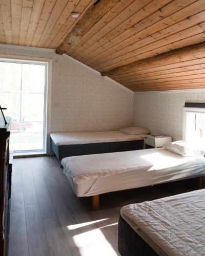 a room with three beds and a large window at Lovely cabin with a beautiful view over Byske river in Byske