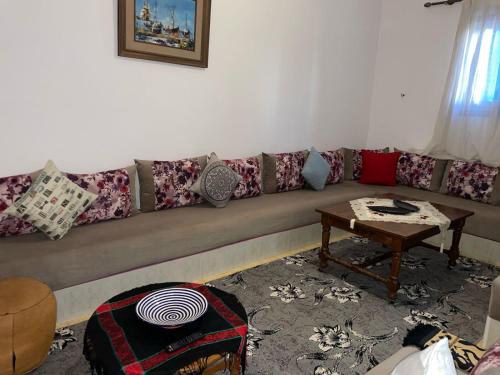 Maison Mina في الوليدية: غرفة معيشة مع أريكة طويلة وطاولة