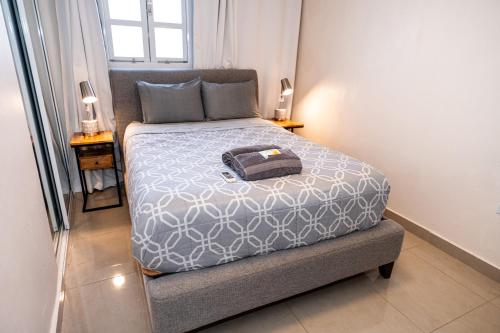 a small bedroom with a bed with a gray comforter at Spacious Retreat with Private Jacuzzi and Terrace in Ponce