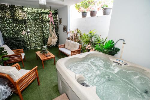- un bain à remous dans un salon orné de plantes dans l'établissement Spacious Retreat with Private Jacuzzi and Terrace, à Ponce