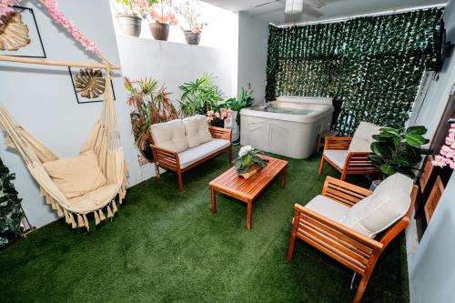 a balcony with a hammock and chairs and a tub at Spacious Retreat with Private Jacuzzi and Terrace in Ponce
