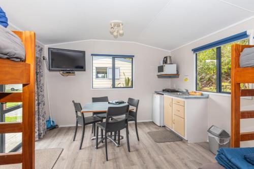 a bedroom with a table and chairs in a dorm room at Blue Lake TOP 10 Holiday Park in Rotorua