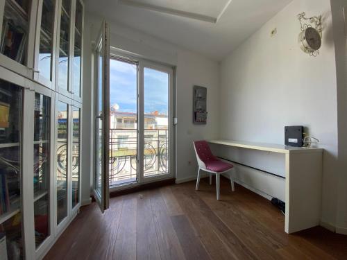 een bureau en een stoel in een kamer met een raam bij CIMI Apartment in Belgrado