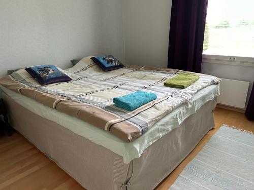 a large bed with two pillows on top of it at Rivitalokaksio *Autokatospaikka* in Seinäjoki