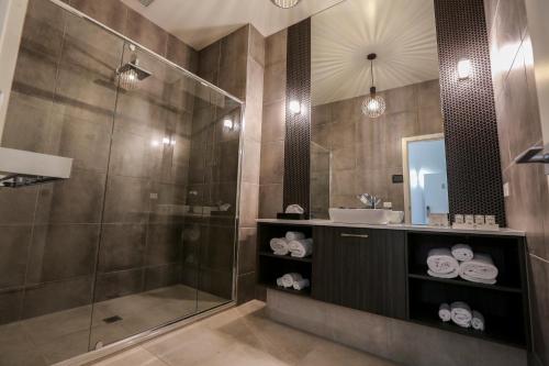 ein Bad mit einer Dusche und einem Waschbecken in der Unterkunft Indulge Apartments - CBD in Mildura