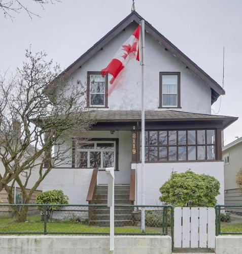 a canadian flag flying in front of a house at John's House in Vancouver West in Vancouver