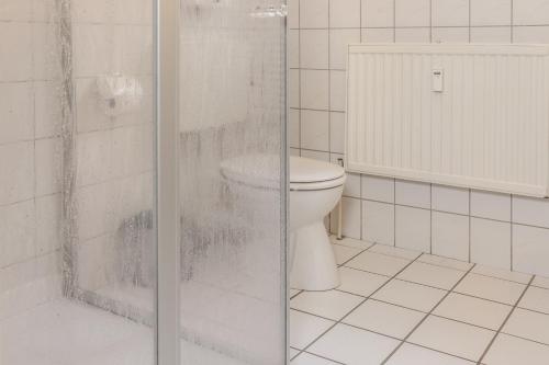 een badkamer met een toilet en een glazen douche bij 50139 Atlantis in Carolinensiel