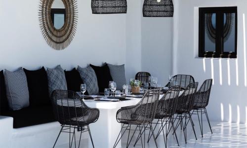 ein Esszimmer mit einem Tisch mit Stühlen und einem Spiegel in der Unterkunft Mbc Psarou Black Retreat 11 Bedrooms Mykonos in Psarrou
