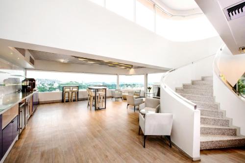 an open living room with stairs and a table and chairs at Hilton Colon Guayaquil Hotel in Guayaquil