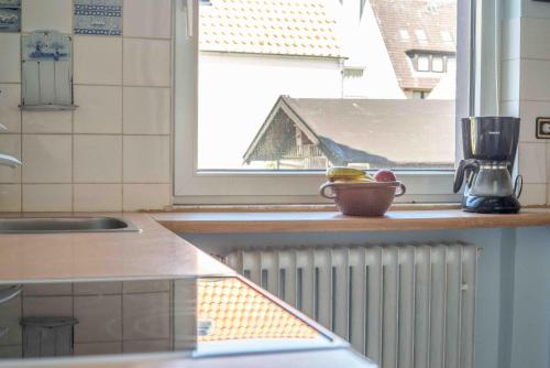 a kitchen with a window and a bowl of fruit on a counter at Haus Küstenzauber Laura & Sarah in Cuxhaven