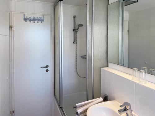 ウィトデュンにあるSüdspitze 34 Whg. 25のバスルーム(シャワー、シンク、鏡付)