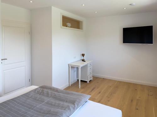 a bedroom with a bed and a tv on a wall at Dünenperle Wanderdüne in Wittdün