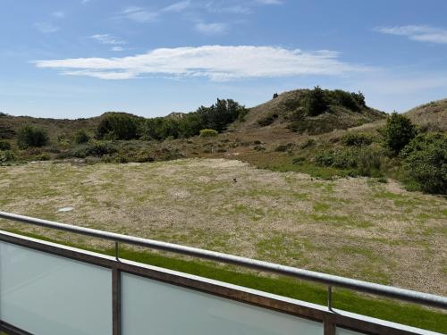 a view of a hill with a fence at Dünenperle Wanderdüne in Wittdün