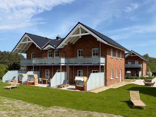 a large brick building with benches in front of it at Dünenperle Wanderdüne in Wittdün