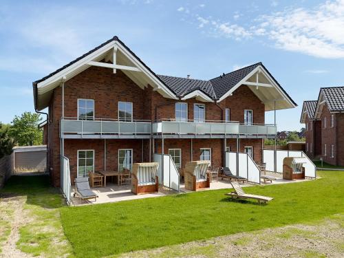 a large brick house with a lawn in front of it at Dünenperle Wanderdüne in Wittdün
