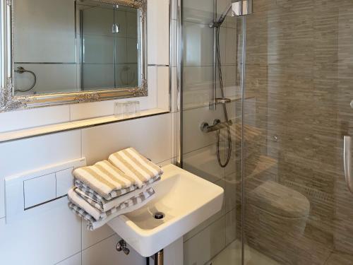 a bathroom with a sink and a shower and towels at Südspitze 34 Whg. 26 in Wittdün