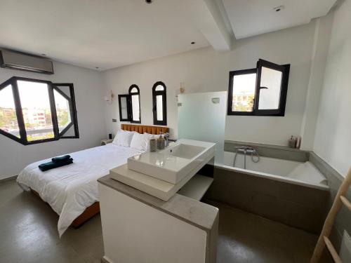 1 dormitorio con cama, bañera y lavamanos en Appartement dans triangle d’or en Marrakech