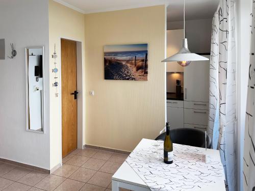 a kitchen with a table with a bottle of wine on it at Südspitze 34 Whg. 23 in Wittdün