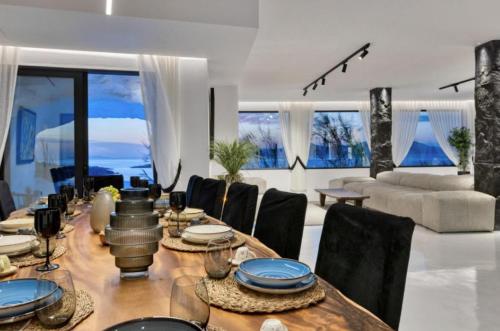 une salle à manger avec une table et des chaises dans l'établissement Exquisite Mykonos Villa Villa Apocryphos 6 Bedrooms Unique Aegean Sea View, à Glastros