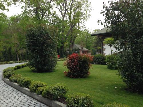 a garden with bushes and a gazebo at RIVER INN RESORT AND SPA in Nabran