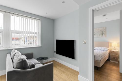Luxurious One Bedroom Apartment in Bond Street في تشيلمسفورد: غرفة معيشة مع أريكة وتلفزيون وسرير