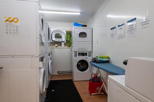 a laundry room with a washer and dryer at Blue Lake TOP 10 Holiday Park in Rotorua
