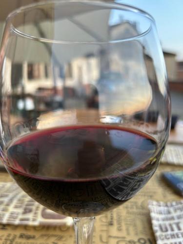 a glass of red wine sitting on a table at Al Vicolo Uno in Montemagno