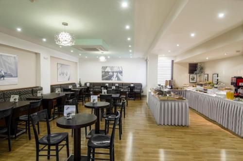 um restaurante com mesas e cadeiras e um bar em Hermes Hotel em Atenas