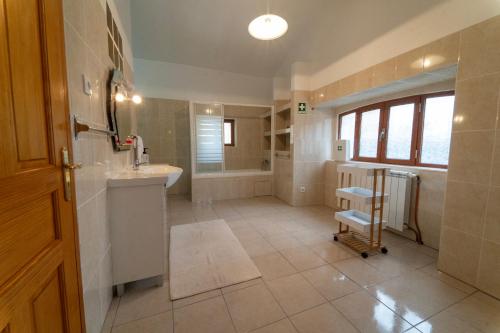 a large bathroom with a sink and a tub at Casa Torre das Andorinhas in Nazaré
