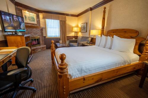 Habitación de hotel con cama, escritorio y TV. en Best Western Fireside Inn en Kingston