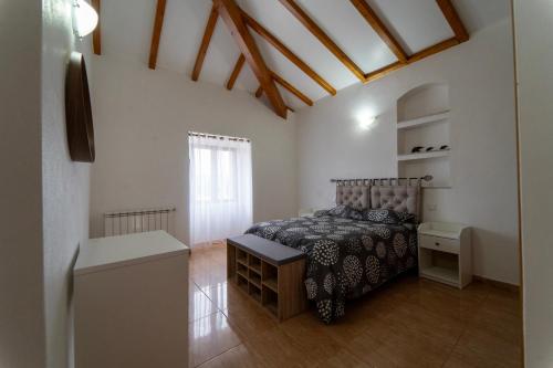 a bedroom with a bed in a room with a window at Casa Torre das Andorinhas in Nazaré